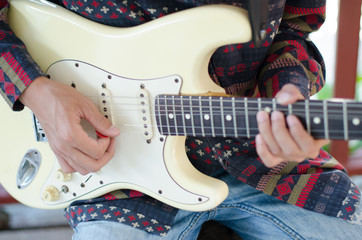 .Young Living and practicing electric guitar happily at home. © Tongra