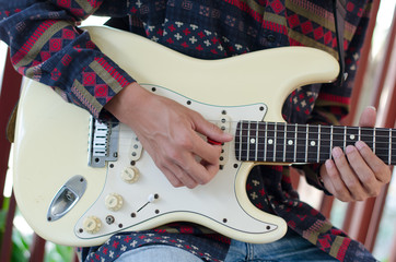 .Young Living and practicing electric guitar happily at home. © Tongra