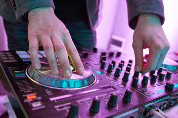DJ plays and mix music on digital midi mixer controller. © Kadmy