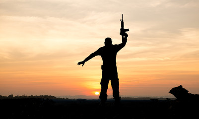 silhouette of soldier on the top of mountain at sunset