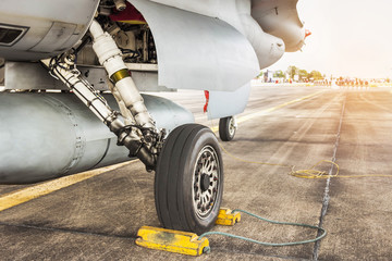 Detail part of wheel and brake system of f16 falcon fighter jet military aircraft on the ground in runway