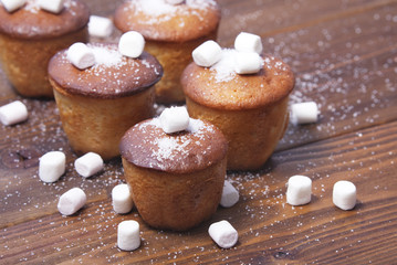 muffins with marshmallow on wooden background