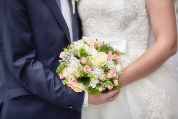 Obraz na płótnie Canvas Bride and groom holding colourful wedding bouquet. Marriage concept