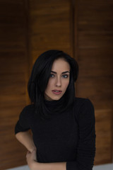 Fototapeta premium Beautiful pensive girl in the black sweater in the Studio