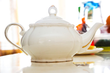 White ceramic teapot on the white table