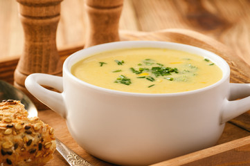 Corn cream soup on wooden background.