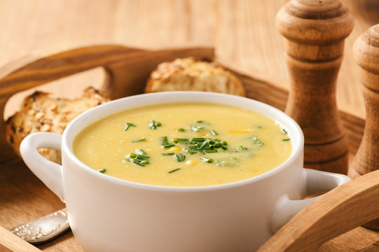 Corn cream soup on wooden background.
