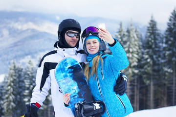 Fototapeta na wymiar A woman takes a photo of herself and her boy.Selfie on the Ski Slope