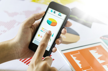 Business concept. Woman's hands using smart phone with financial