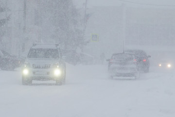 poor visibility on the road during a snowfall , the movement of vehicles in winter conditions