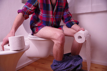 Mann auf der Toilette, Stuhlgang