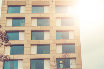 very modern apartment house with orange marble facade and blue windows