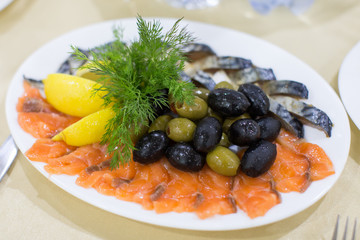 fresh roast wild pink salmon meat fillet with black olives and raw lemon