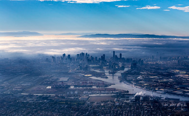 Fototapeta premium Panoramę Melbourne z drapaczami chmur wyłaniającymi się z porannej mgły