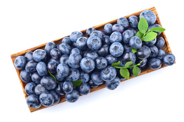 blueberries in wooden dish isolated on white
