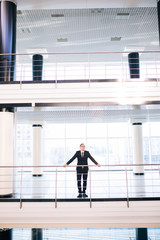 Young business man in big office look around all working hall