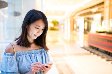 Woman use of mobile phone at shopping mall