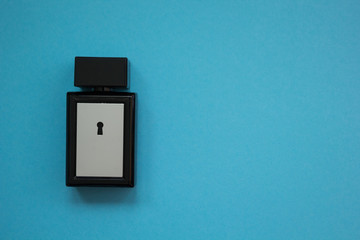 A square bottle of perfume on a blue background.