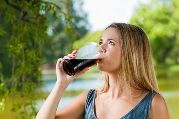 Teenager drinking a glass of soda