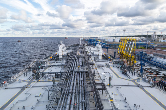Oil product tanker loading from shore terminal.
