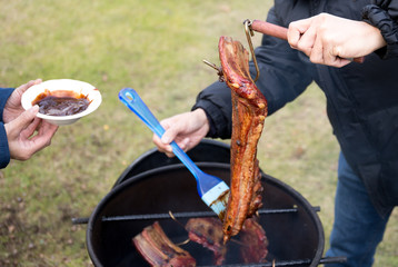 Man brushing sauce on barbecue spare ribs