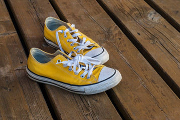 Cool teenager yellow sneakers on wooden background