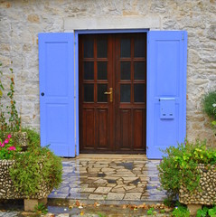 Fototapeta na wymiar Wejście do domu i niebieskie okiennice