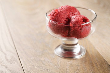raspberry sorbet ice cream balls on wooden table, shallow focus