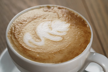 fresh cappuccino cup with art close up photo, shallow focus
