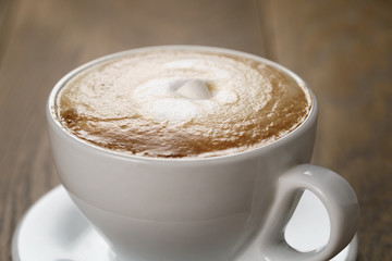 cup of cappuccino with marshmallow on wooden table, shallow focus