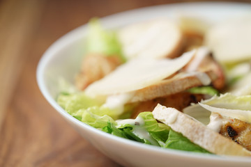 macro shot of fresh homemade caesar salad with chicken, shallow depth of field