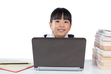 Happy Asian Chinese little girl wearing school uniform using lap