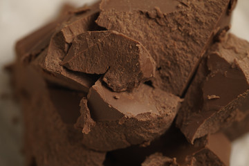 chunks of gianduja hazelnut milk chocolate on paper, closeup photo