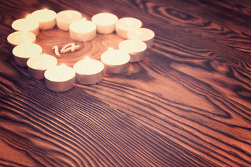 love symbol made from many small candles on wooden background