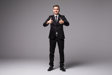 Young businessman in suit thumbs up isolated