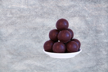 Chocolate balls pile - sweet candies stack - on white.