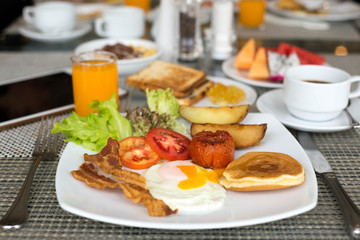 Breakfast set on the table with pancakes, bacon