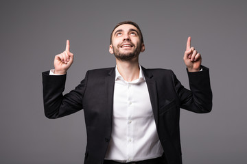 Young businessman in suit pointed and look up  isolated