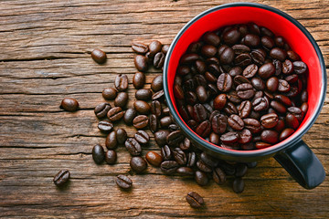 Coffee cup and coffee beans on wooden table