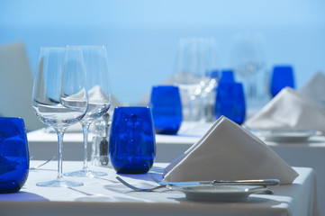 Elegant clean simple white linen restaurant table setting glass silverware china