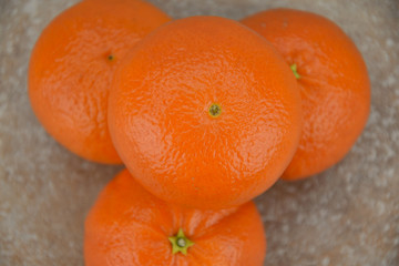 Tropical fruit mandarin orange, standing on a ceramic tile. Detail.