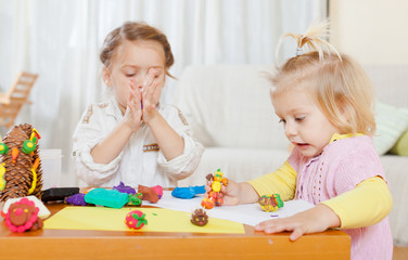 Preschoolers molding figurines from plasticine .