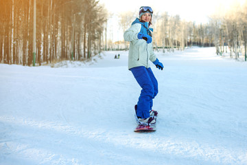 Fototapeta na wymiar female snowboarder snowboarding down the mountain