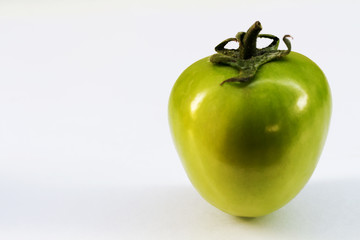 Green tomato on white background.