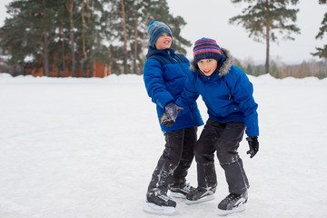 Fototapeta na wymiar two skater brothers on the ice