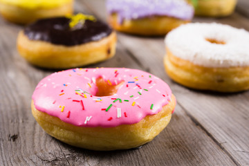 Different kinde of round donuts on wooden table. Closeup