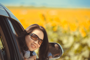 Portrait happy, smiling woman sitting in the car looking out windows, ready for vacation trip
