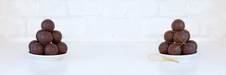 Chocolate balls pile - sweet candies stack - on white. Wide panoramic image.