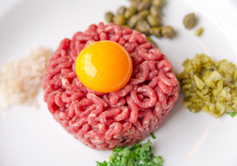 Beef tartare with egg yolk on a white plate, Paris, France