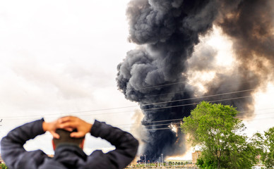 A huge smoke surprises a man a few meters from a fire
